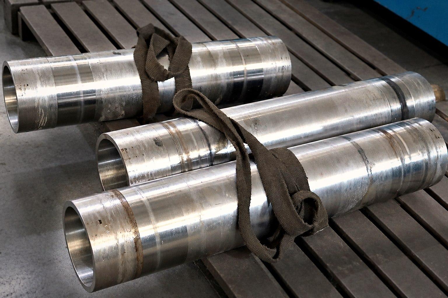Desenho técnico e peça de aço inox usinada sobre a bancada para pedido de orçamento sob medida